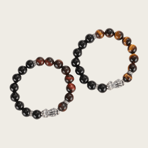 A pair of High-quality 999 sterling silver couple bracelet with black onyx , one with red tiger eye beads and the other with yellow tiger eye beads, featuring a traditional Pixiu charm – symbol of love, protection, and good fortune.