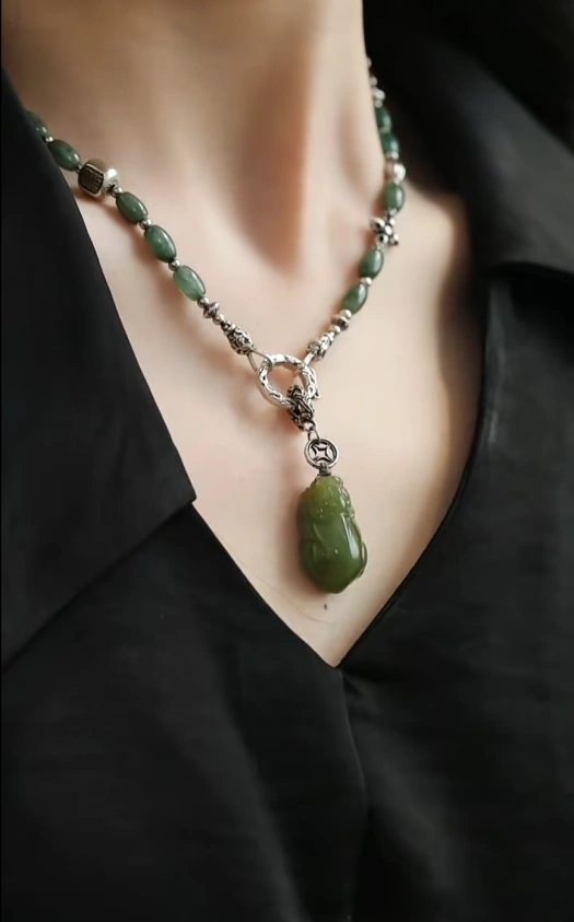 Feng Shui necklace with green jade beads and a Pi Xiu pendant, symbolizing wealth and prosperity, with silver detailing.